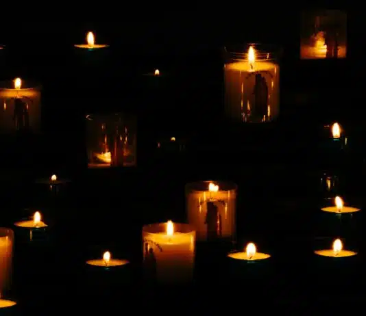 lit yellow candles in the dark